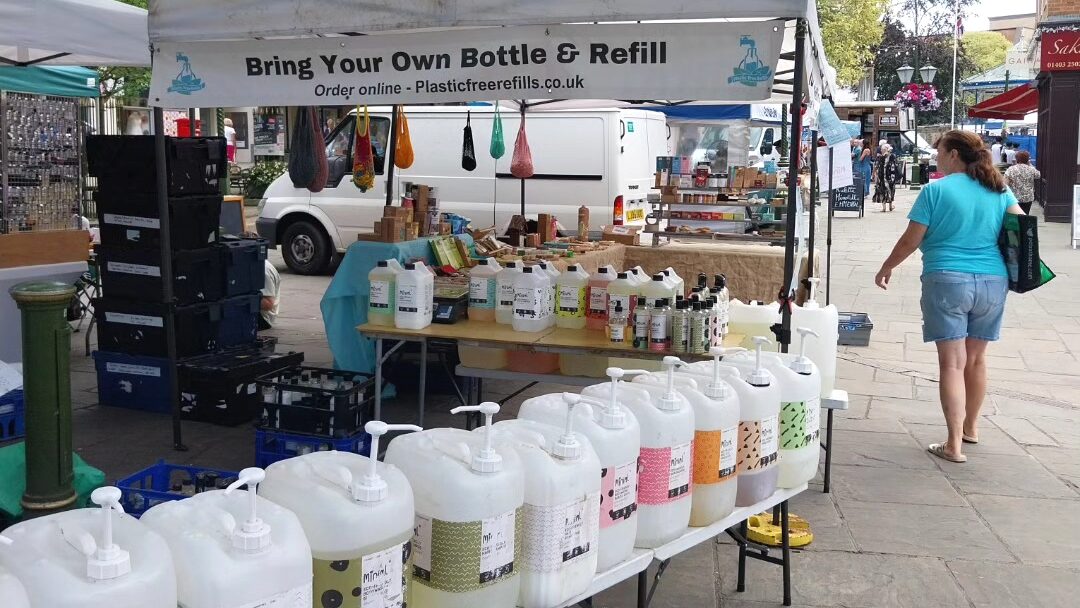 Plastic Free Refills stall at Horsham Market with rows of refill containers